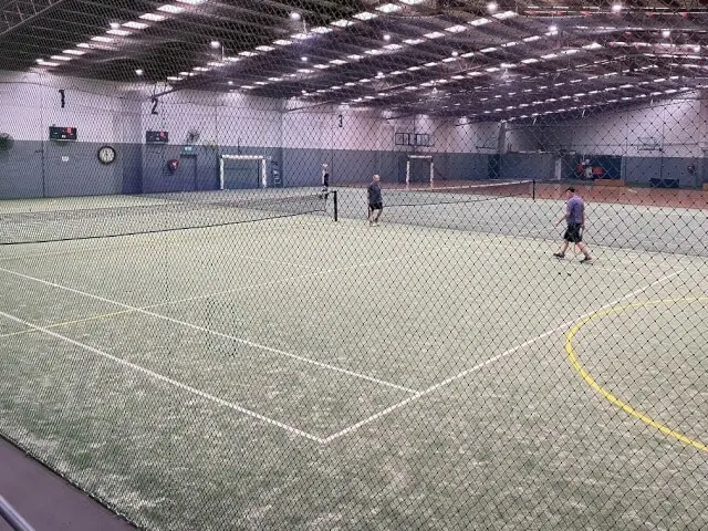 Indoor green synthetic grass tennis courts at Raikich Tennis Academy
